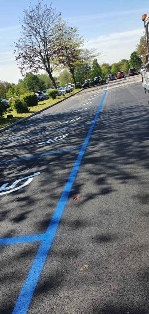Places PMR avec marquage au sol bleu sur parking extérieur par Lambert Marquage