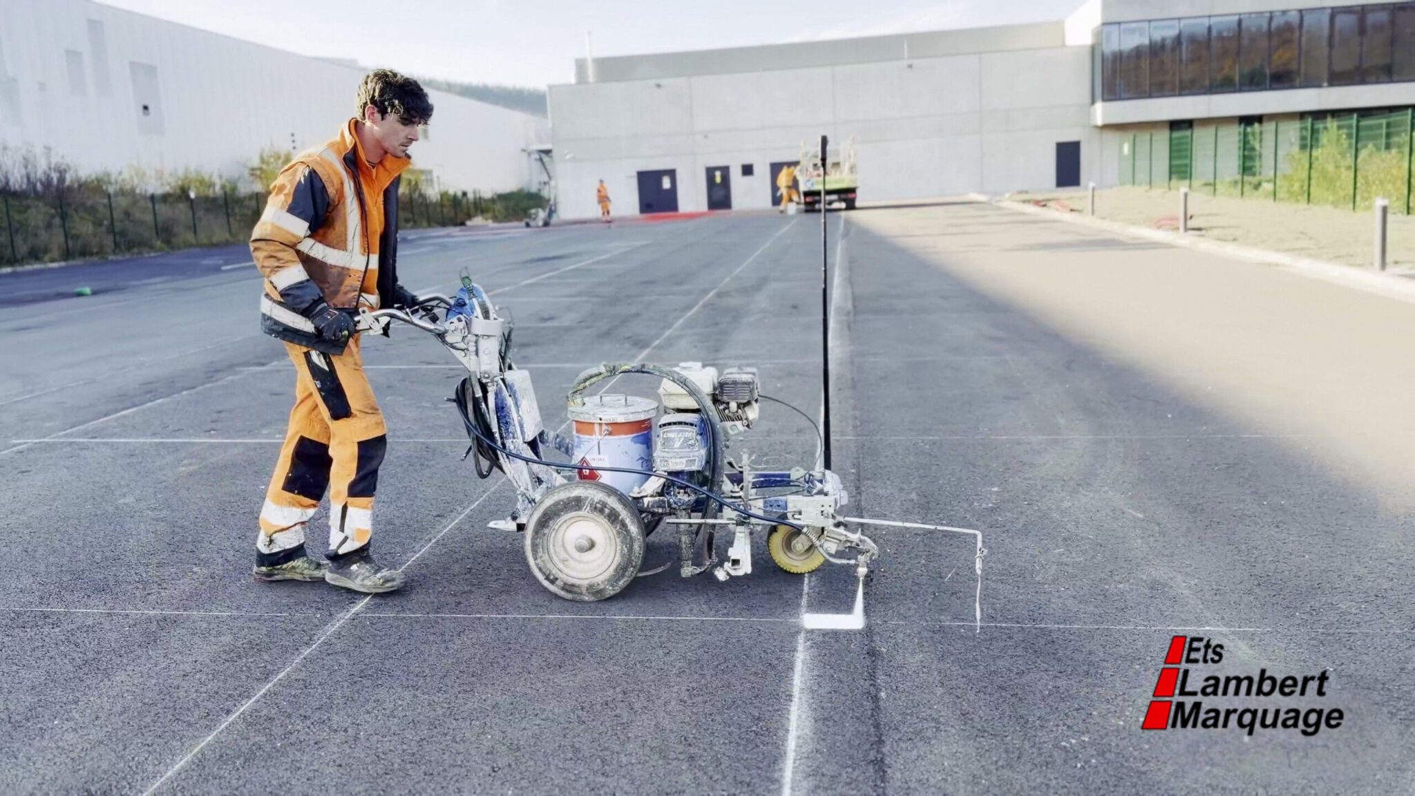 Opérateur en train de tracer des lignes de parking avec une machine de marquage au sol par Lambert Marquage