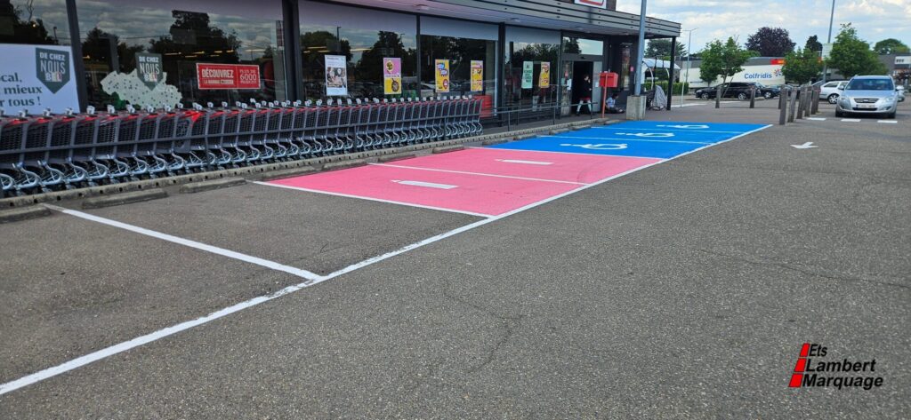 Places de parking colorées et marquage au sol devant un supermarché par Lambert Marquage